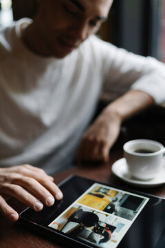 Young Man Using Computer Seated in a Coffee Shop