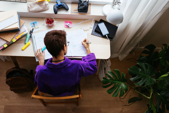 Focused teen studying at desktop in personal room