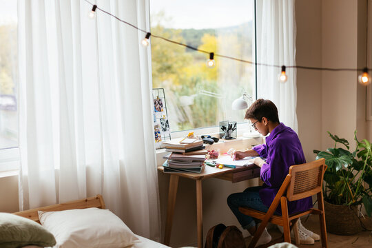 Focused kid studying alone in cozy bedroom