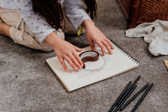 Little girl drawing on the floor at room