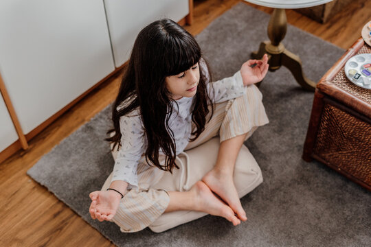 little girl practicing yoga at bedroom 