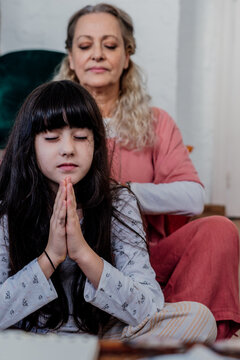 grandmother and granddaughter praying at room 