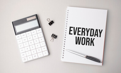 The word everyday work a is written on a white background next to a pen ,calculator and reports. Business concept