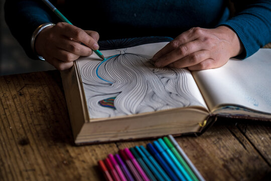 artist is doodling and colouring in her sketchbook