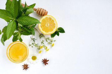 Top view of a cup with honey, lemon, mint, anise and herbs on a white background. Flat lay, copy space