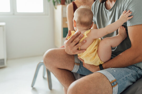 Father Carefully Holding Baby In His Strong Arms