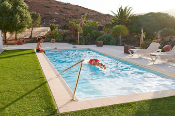 Senior men swimming in a pool in summer