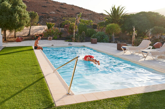 Senior men swimming in a pool in summer