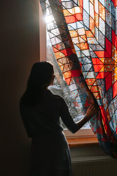 A woman looks out of a window.