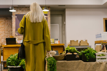senior woman shopping eco vegetables at waste store