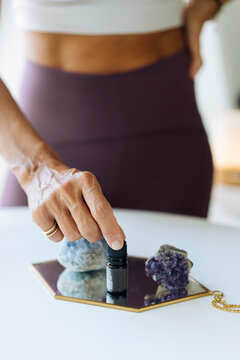 Woman preparing for yoga session with essential oil