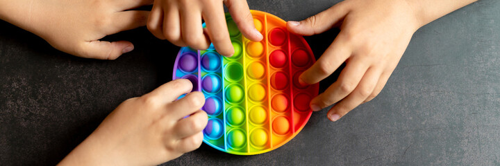 anti stress sensory pop it toys in a children's hands. a little happy kids plays with a simple...