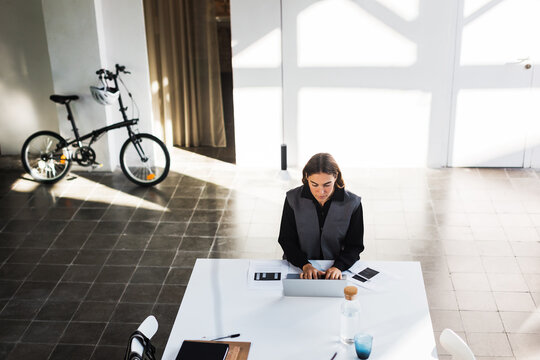 Smart woman using laptop in stylish workplace