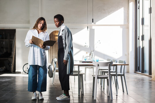 Diverse coworkers reading documents in folder