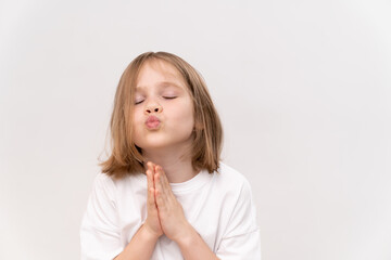 cheerful and happy little girl with a haircut quad holds his folded hands in front of her on white...