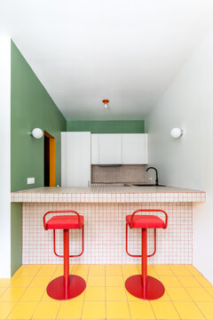 Two red stools in a colourful kitchen