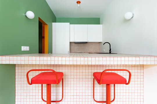 Two red stools in a colourful kitchen 