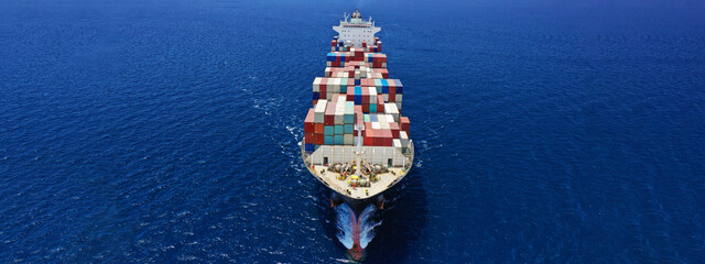 Aerial drone ultra wide panoramic photo of colourful truck size container tanker ship cruising deep...