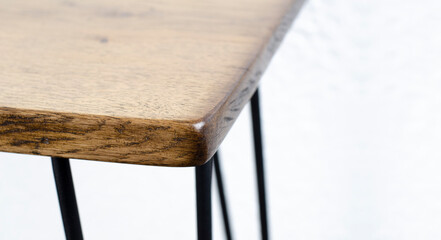 Corner of a wooden oak table in a loft style. In the room. Furniture and fittings.