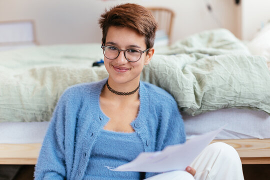 Teen student with papers smiling for camera