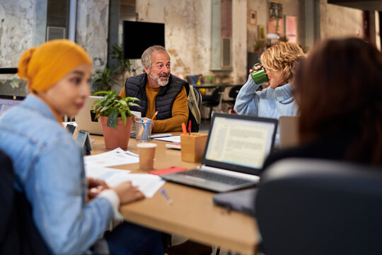 Colleagues chatting during coffee break in workplace