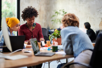 Diverse female colleagues analyzing data together