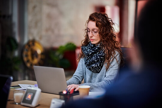 Smart woman using laptop in workplace