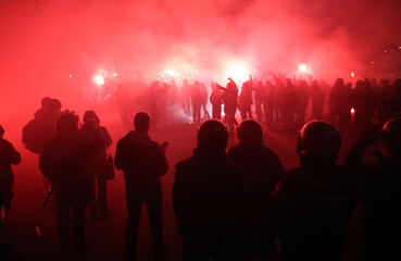 Fototapeta na wymiar Police looking at football fans with torches