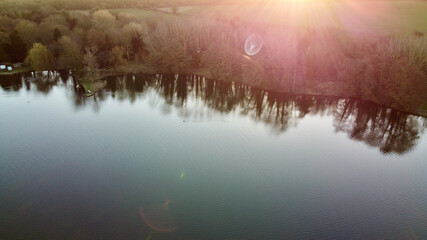 Aerial view of sunset reflection upon clear lake.