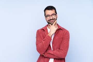 Young caucasian man wearing corduroy jacket over blue background smiling