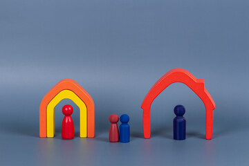 Divorce, conflict between parents, children custody, property division. Wooden houses, miniature figures of parents and children on gray background