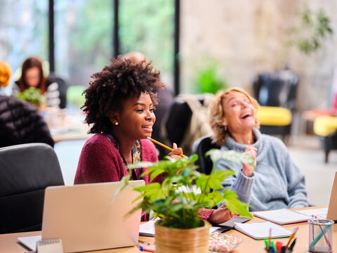 Businesswomen laughing at joke in office