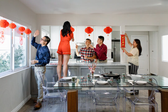 Chinese Family Decorates the House for New Year