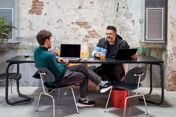 Male coworkers discussing project together