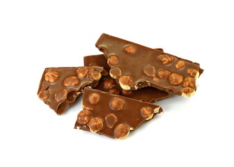 A broken pieces of chocolate with hazelnuts isolated on white background. Milk chocolate tiles with nuts isolated on white.