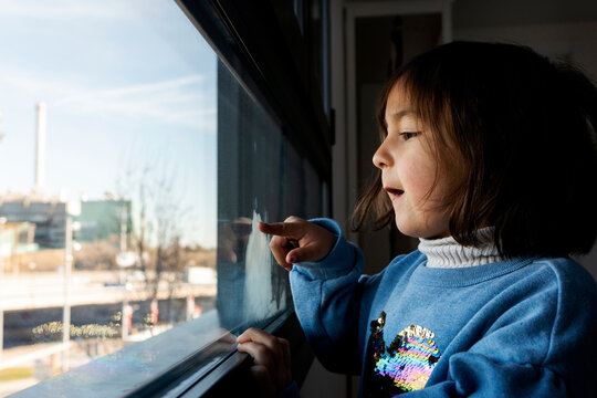 little girl looking trough the window