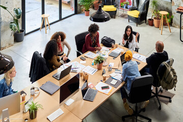 Talking colleagues at mutual desk.