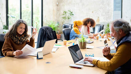 Middle aged coworkers analyzing data