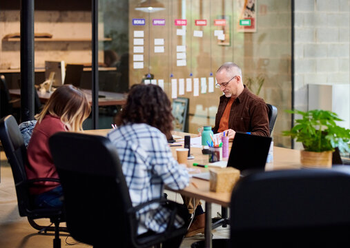 Man reading papers near colleagues