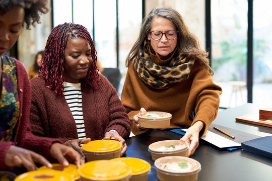 Diverse coworkers sharing delivery food for lunch