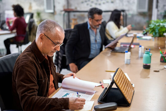 Middle aged employee analyzing graphs in workplace