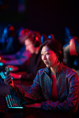 A pretty streamer girl is broadcasting on twitch from a dota tournament among esports players