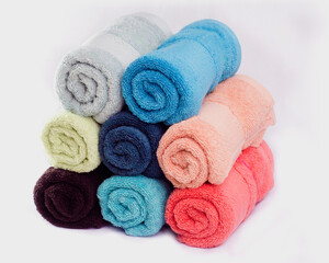 Hand and Face Towels in assorted colours stack on white background