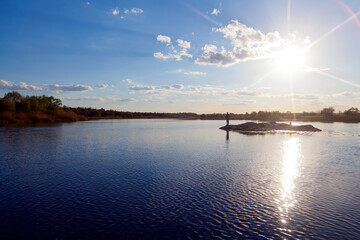 Fototapeta na wymiar Silhouette of fisherman fishing on small island in the river