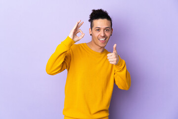 Caucasian man over isolated background showing ok sign and thumb up gesture