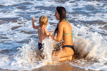 Fototapeta premium MÃE E FILHO BRINCANDO NA PRAIA.