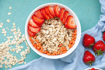 Oatmeal with strawberries, in a bowl on a wooden table background. Healthy breakfast food