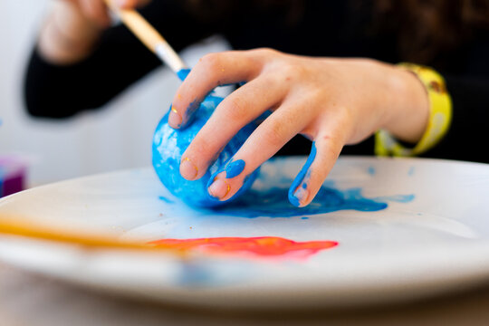 Little girl painting the planet earth with brush 