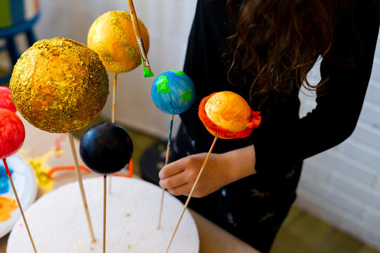 Young girl making a handmade Solar System Craft at home