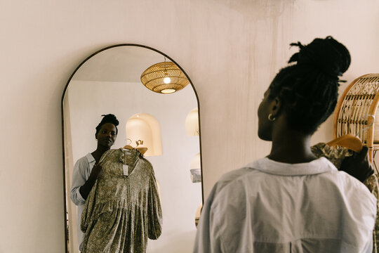 African Woman Trying on Dress in Boutique